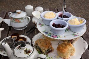 Une image de cream tea: du thé avec des scones, de la confiture, de la crème ou du beurre 