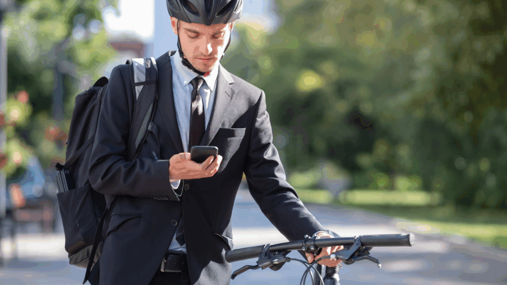 Image d'un homme d'affaires regardant son téléphone avant de monter sur son vélo pour se rendre au travail - 5 expressions du quotidien en anglais