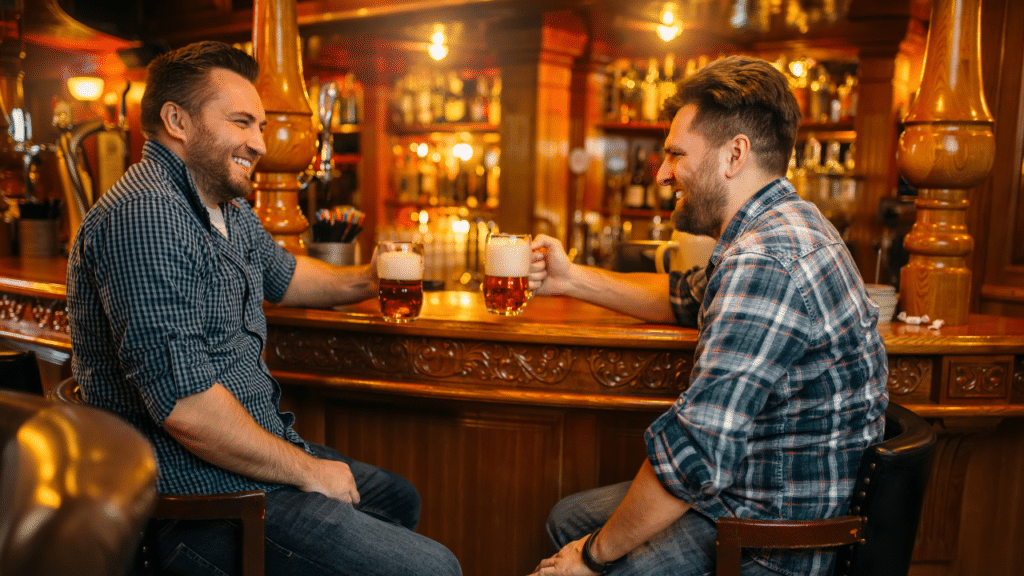 Comprenez-vous le VRAI anglais - Photo de deux hommes en train de boire une bière et de discuter dans un bar